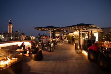 a group of people sitting at tables on a rooftop