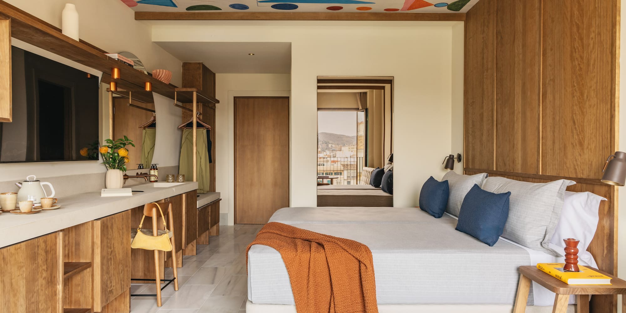 Colorful abstract ceiling in modern hotel room with wood accents.