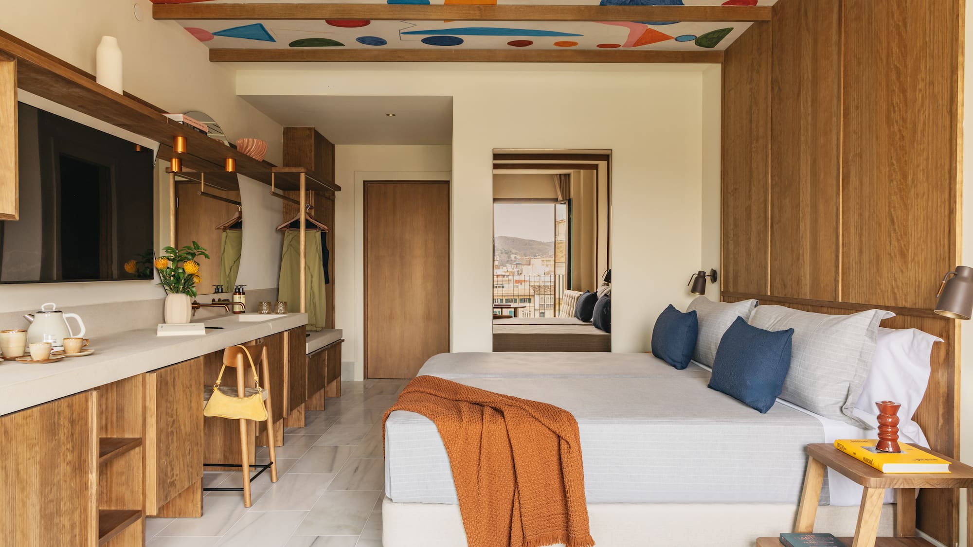 Colorful abstract ceiling in modern hotel room with wood accents.