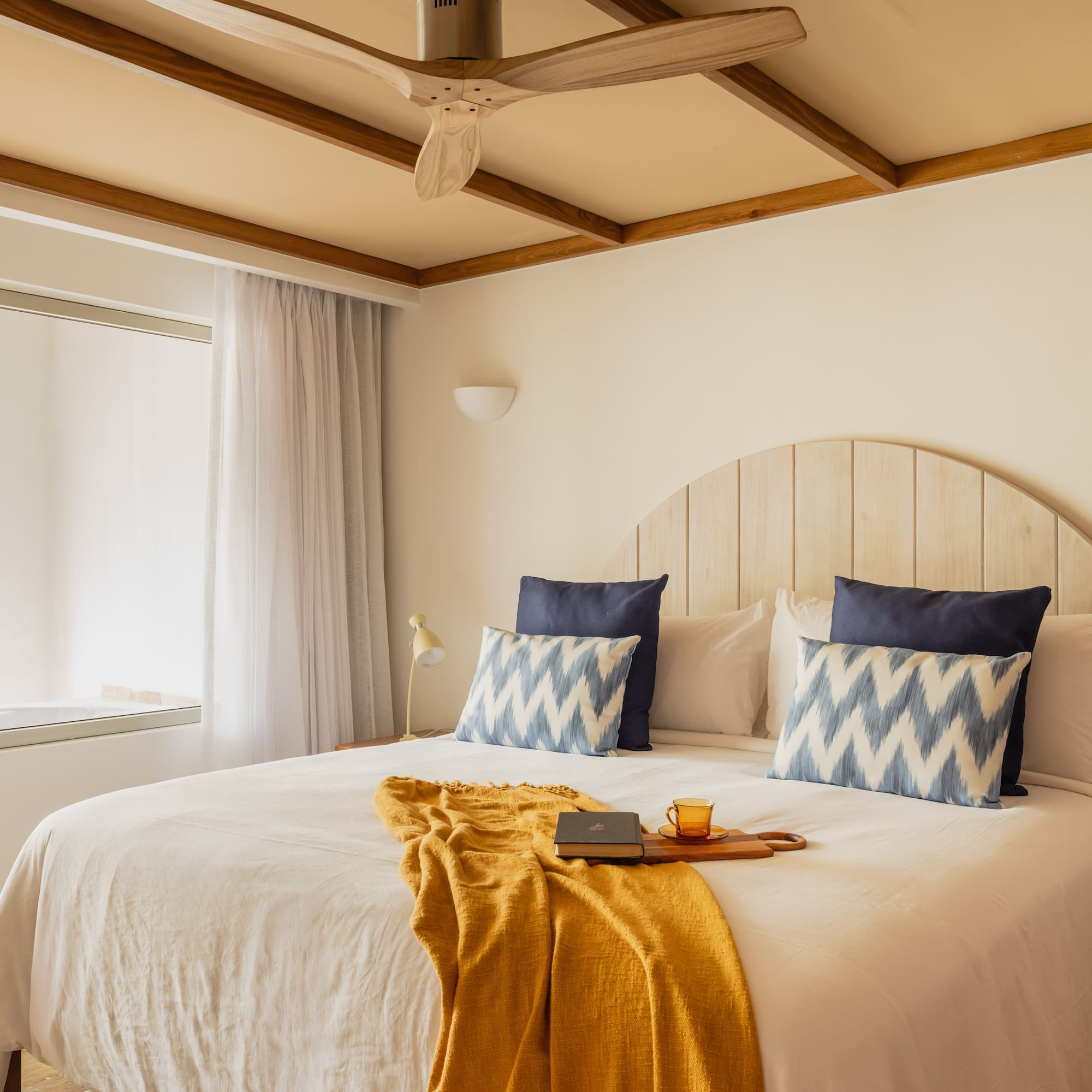 a bed with a fan and a book on it