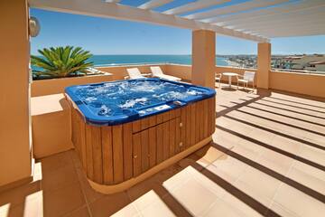 a hot tub on a deck with a view of the ocean
