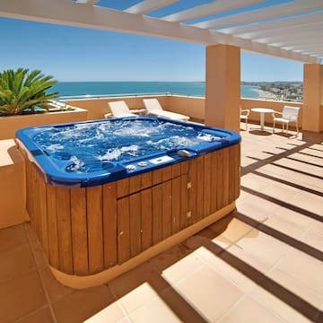 a hot tub on a deck with a view of the ocean