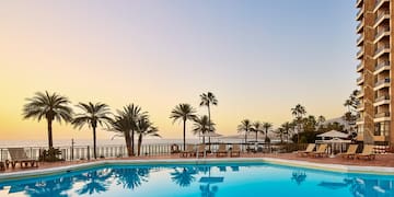 a pool with palm trees and a deck chair