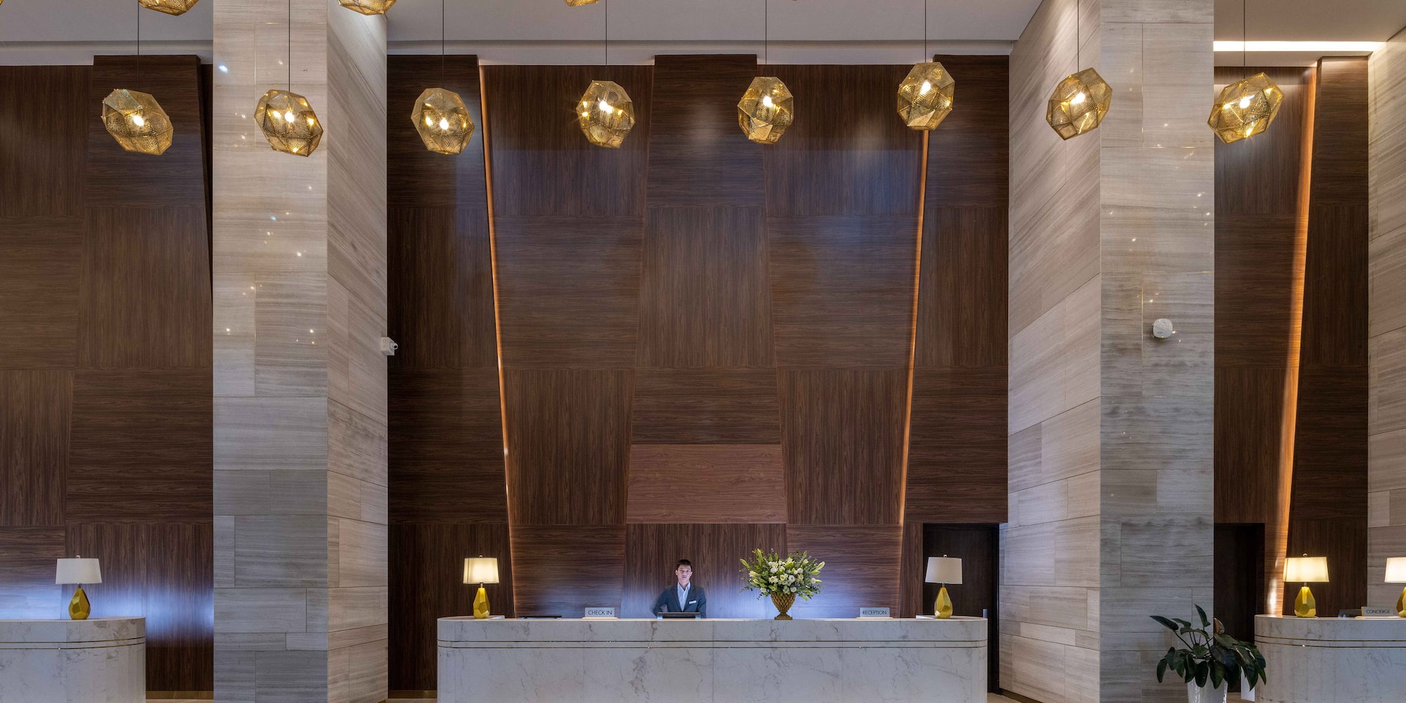 a man at a reception desk in a hotel