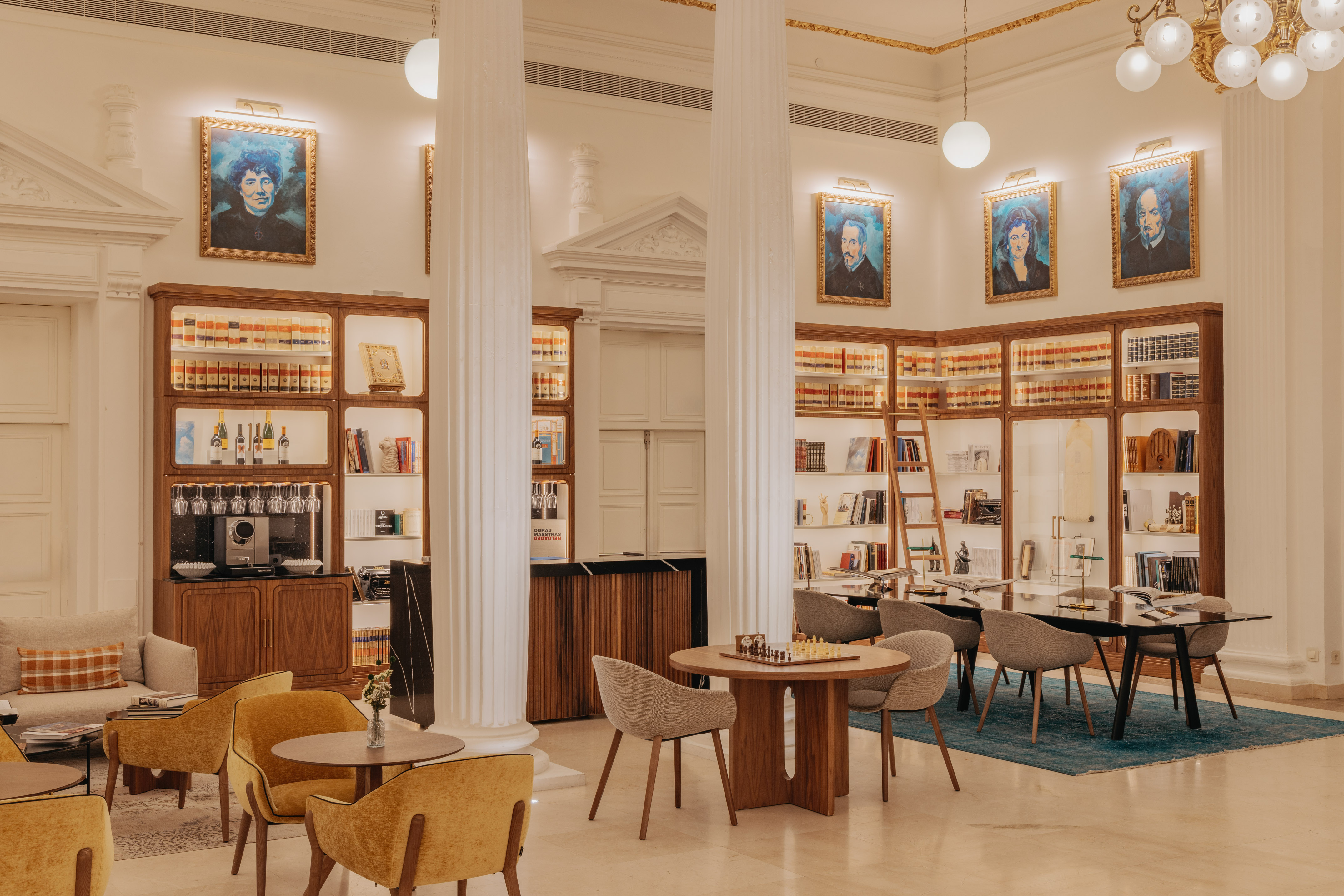 Elegant library lounge with bookshelves, portraits, seating, and a chessboard.