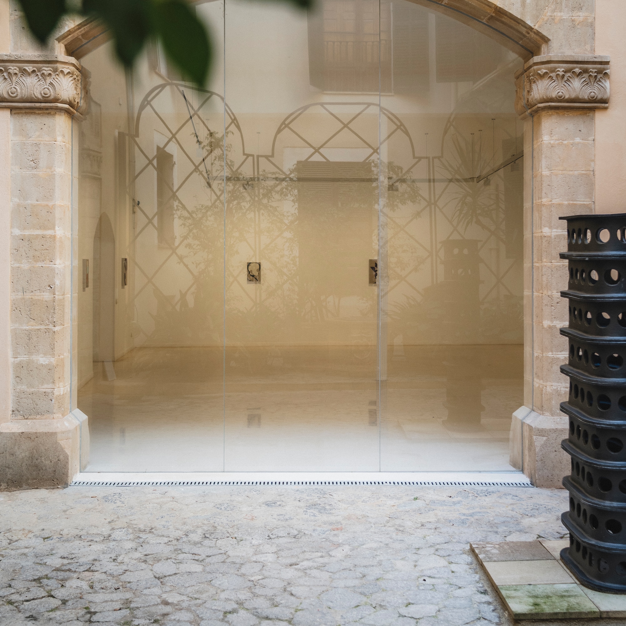 a glass door with a black trash can next to it