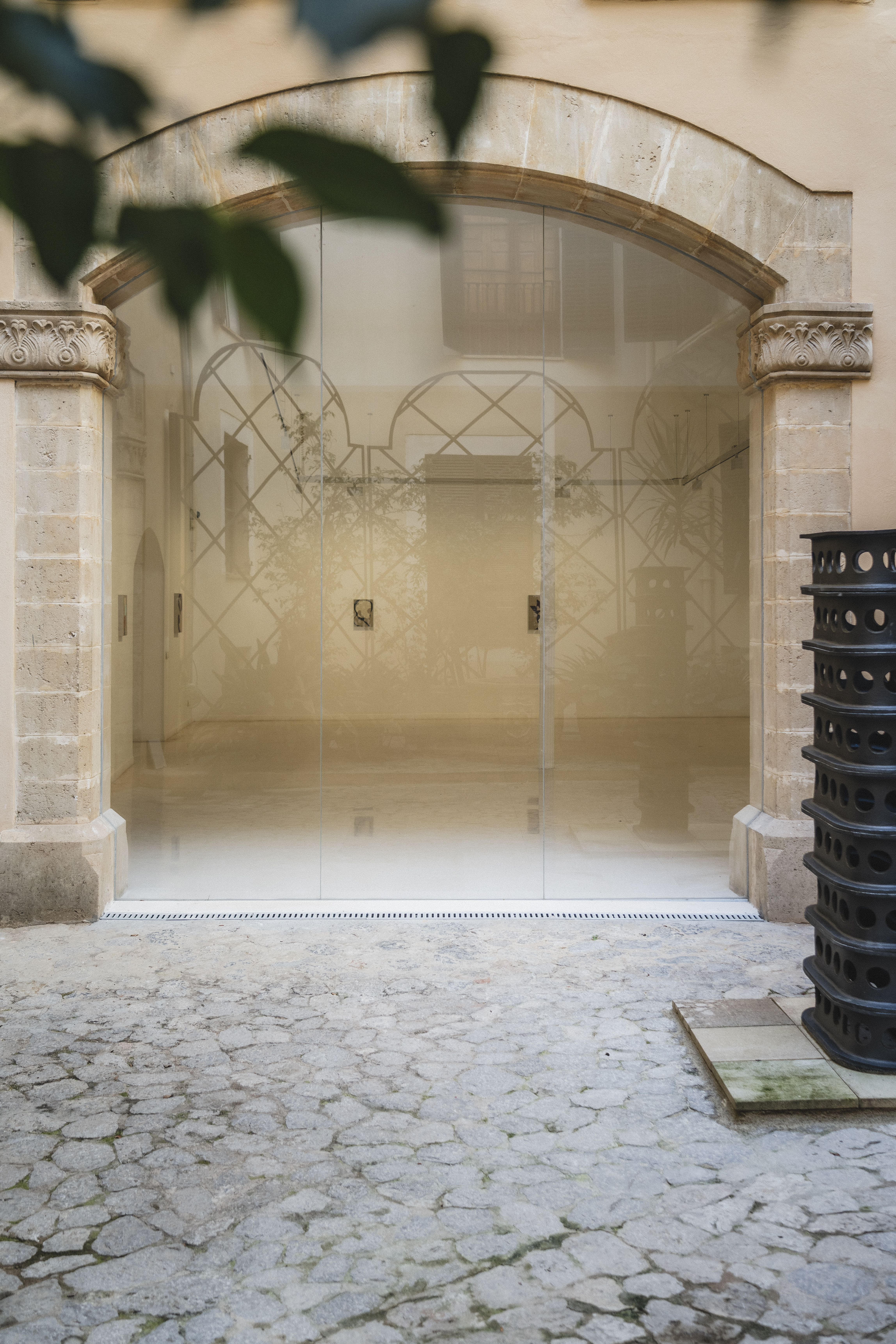 a glass door with a black trash can next to it