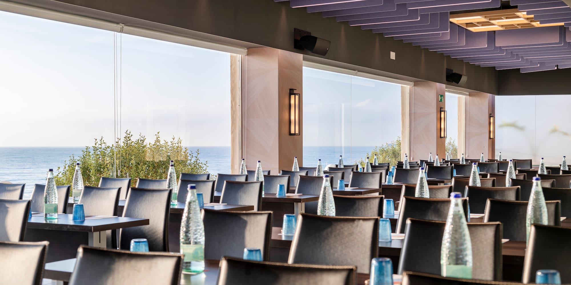 a room with tables and chairs with water bottles