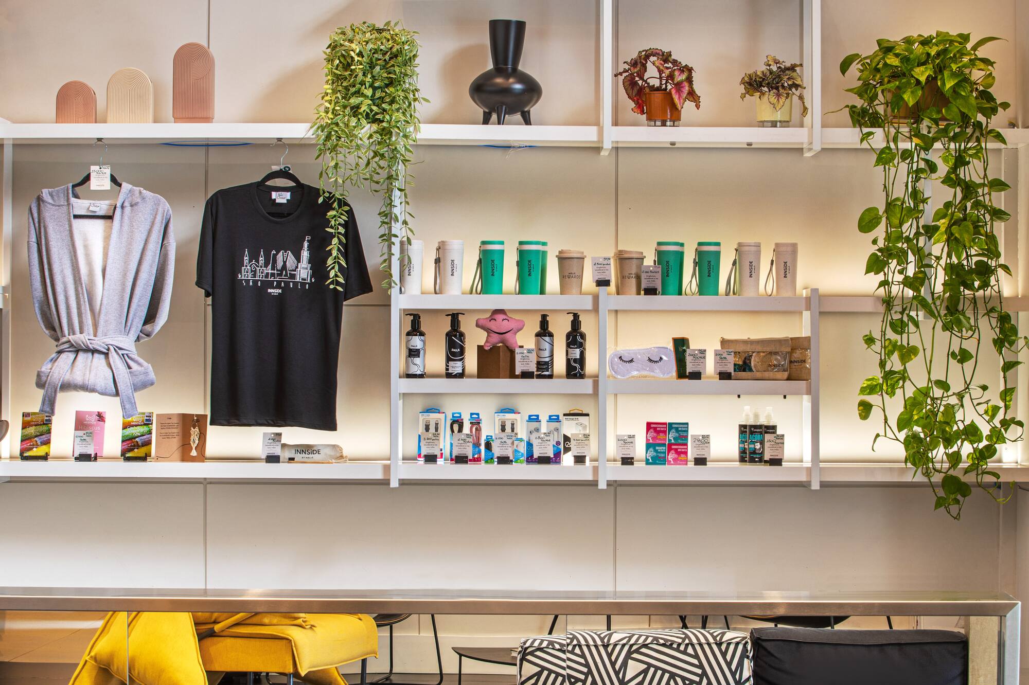 Modern hotel gift shop with merchandise, plants, and lounge seating.
