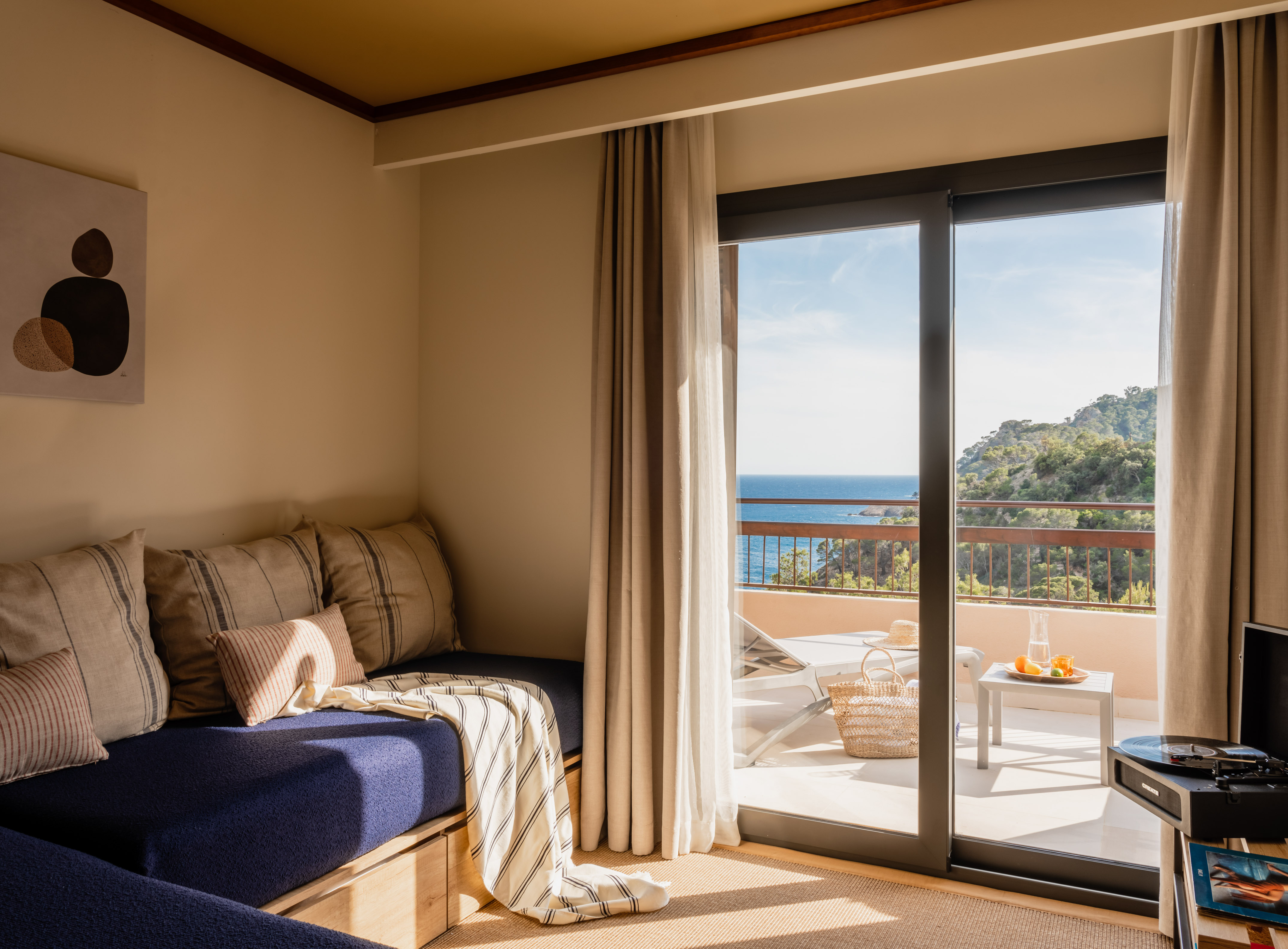 Cozy room with balcony, ocean view, daybed, and record player.