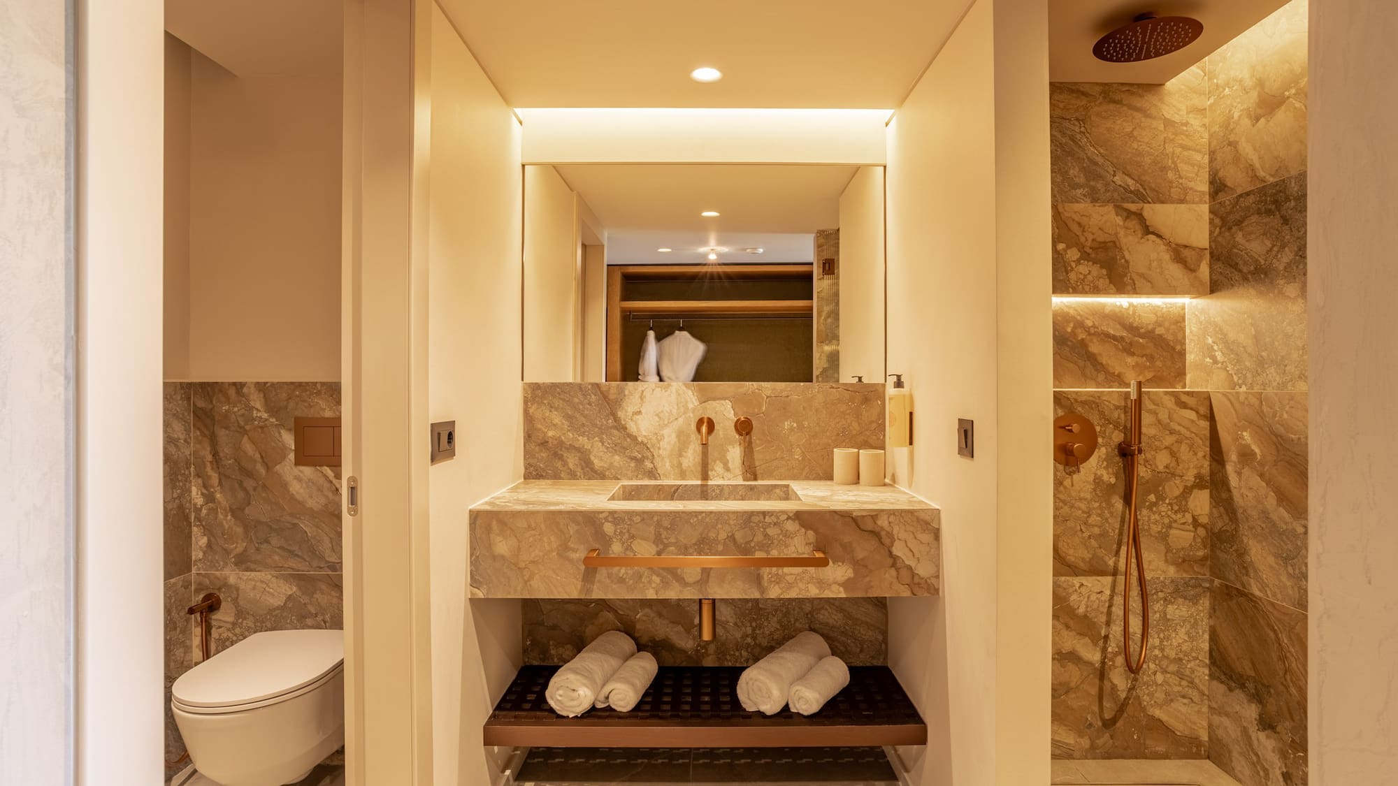 Modern bathroom with marble vanity, copper fixtures, and a walk-in shower.