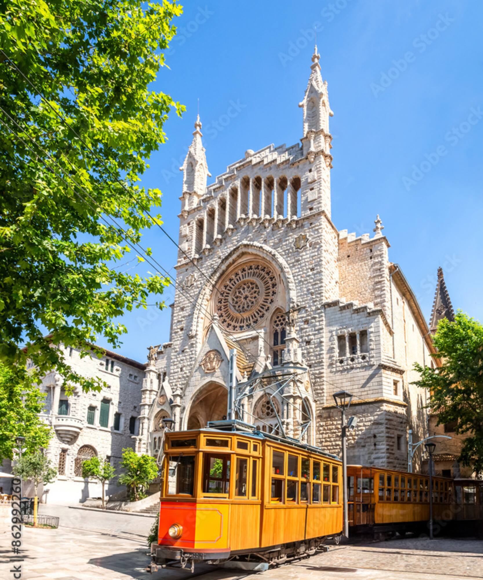 Vintage wooden tram by ornate Gothic church with rose window.