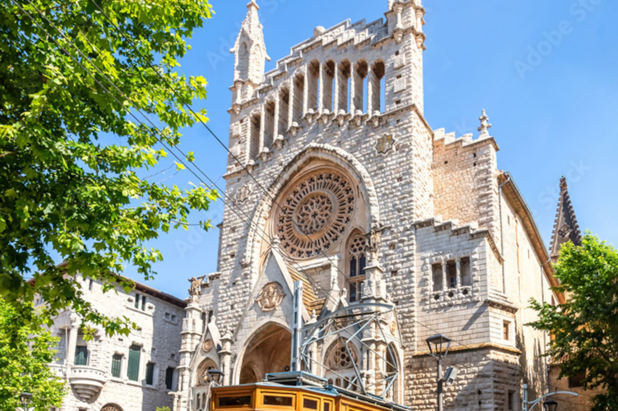 Vintage wooden tram by ornate Gothic church with rose window.
