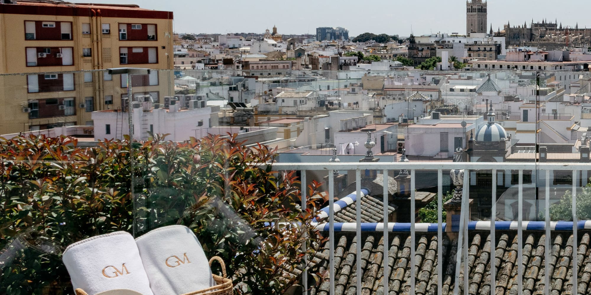a basket with towels and a hat on a balcony overlooking a city