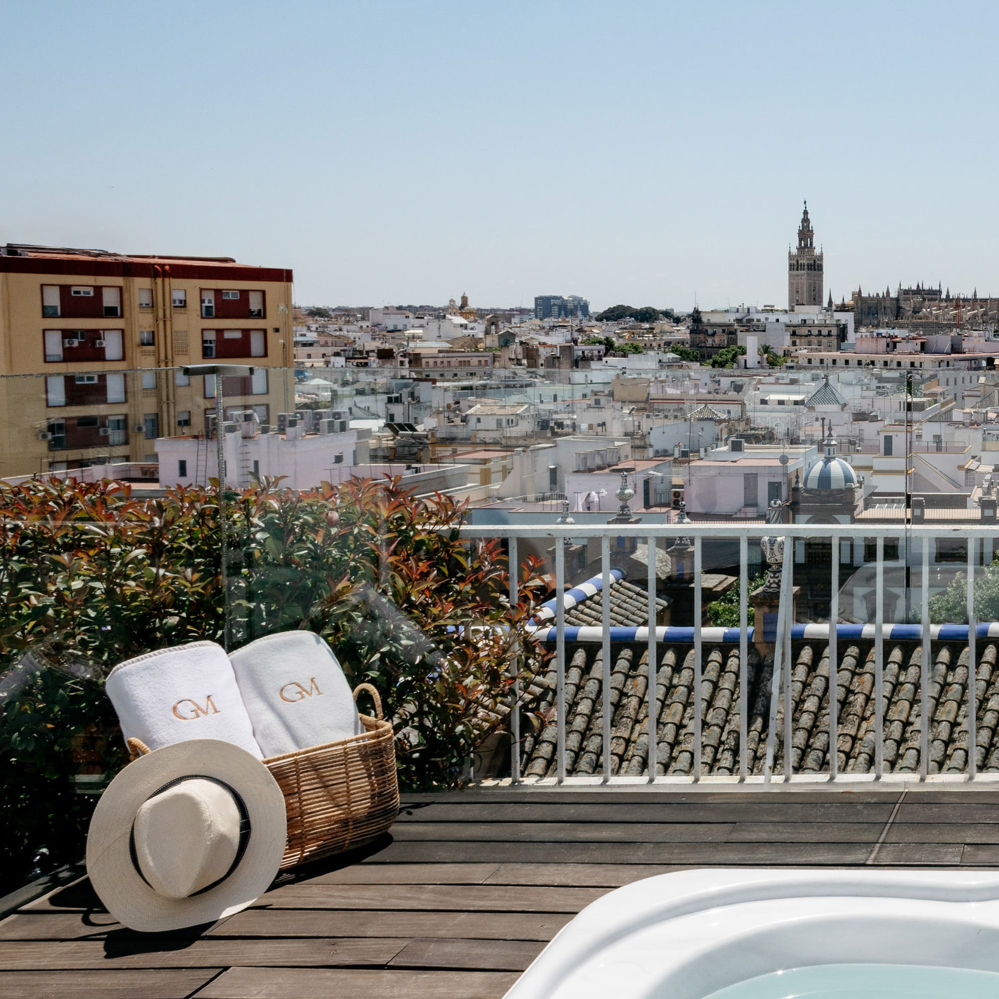 a basket with towels and a hat on a balcony overlooking a city