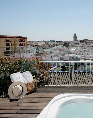 a basket with towels and a hat on a balcony overlooking a city