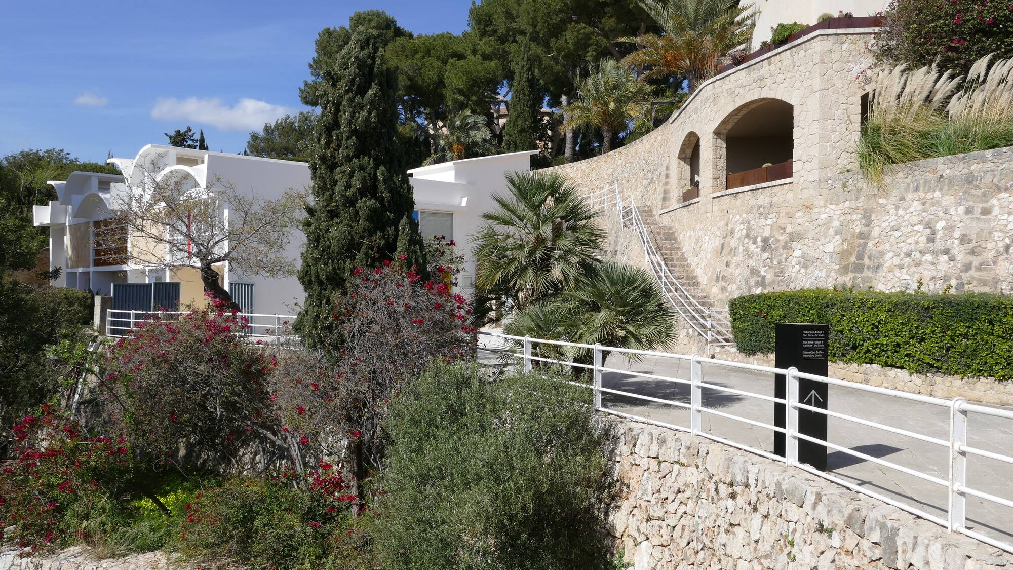a stone wall with trees and bushes
