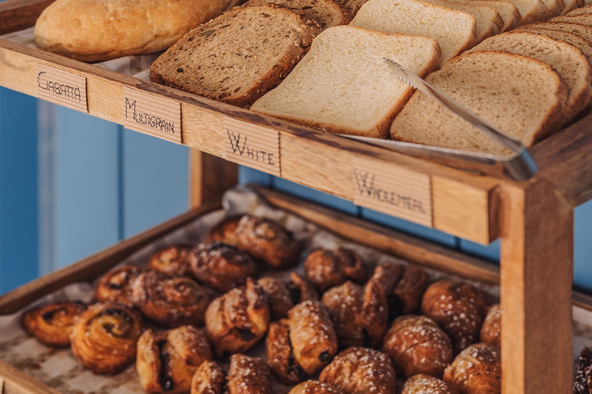 Breakfast buffet with fresh sliced bread, croissants, and pain au chocolat.
