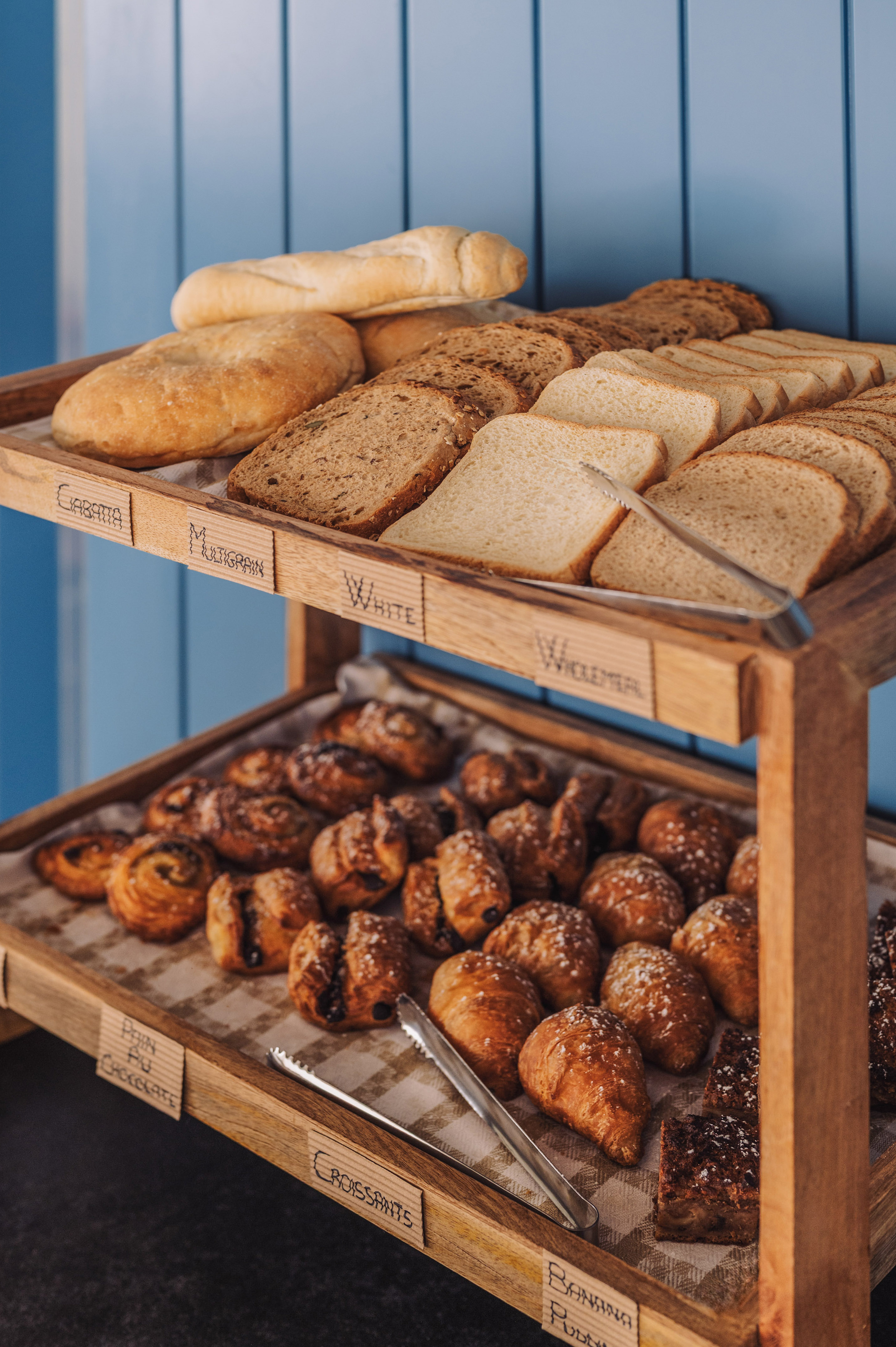 Breakfast buffet with fresh sliced bread, croissants, and pain au chocolat.