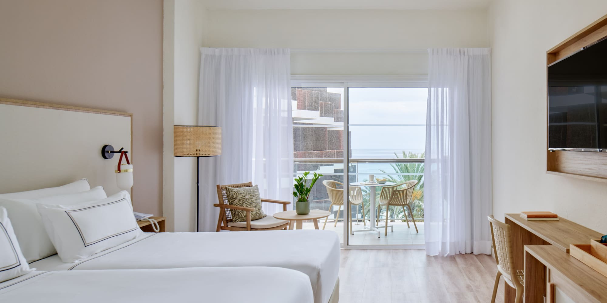 a room with two beds and a table and chairs