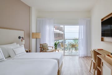 a room with two beds and a table and chairs