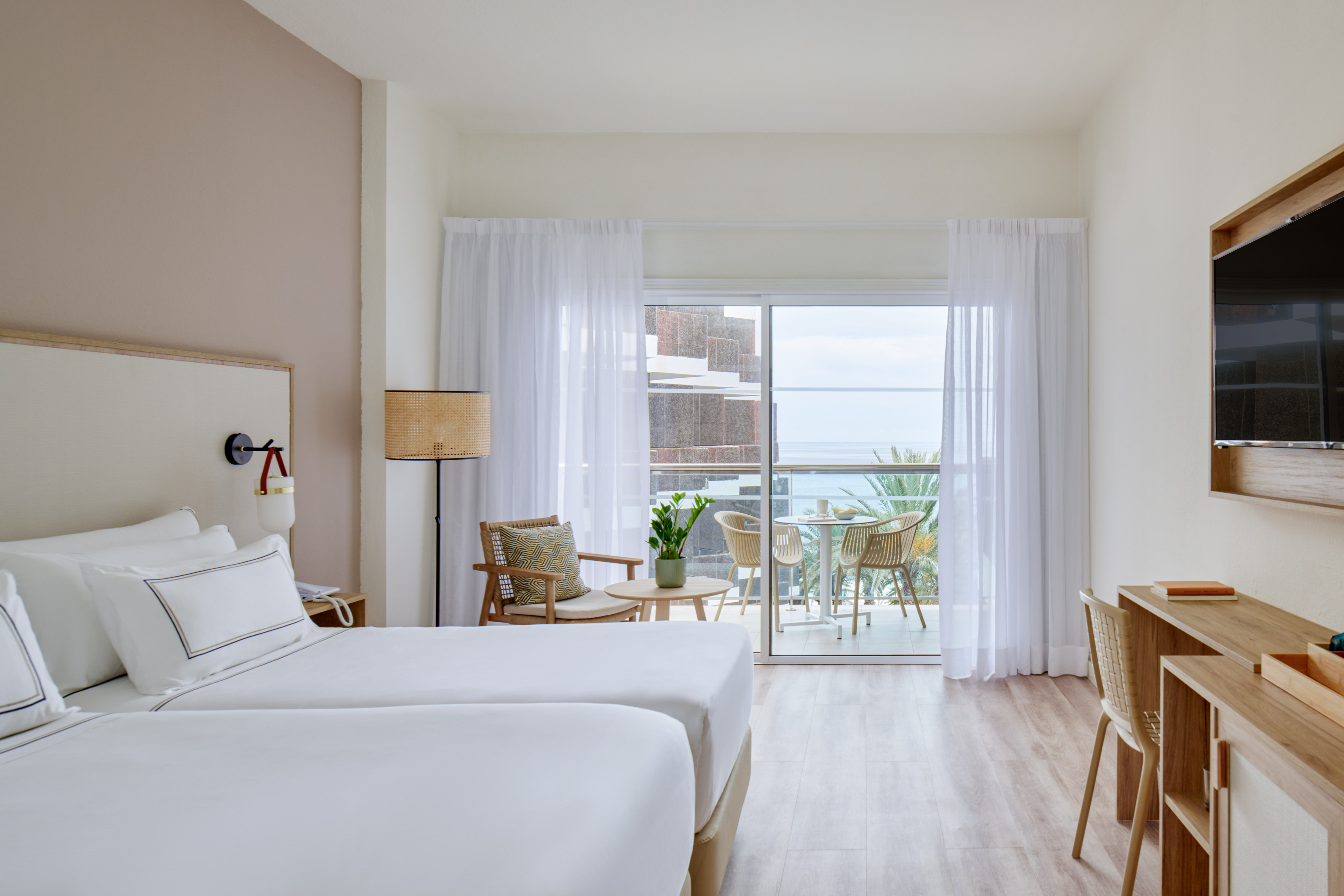 a room with two beds and a table and chairs