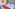 Modern hotel room with twin beds, orange bed runners, and abstract art.