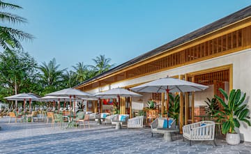 a building with tables and chairs and umbrellas