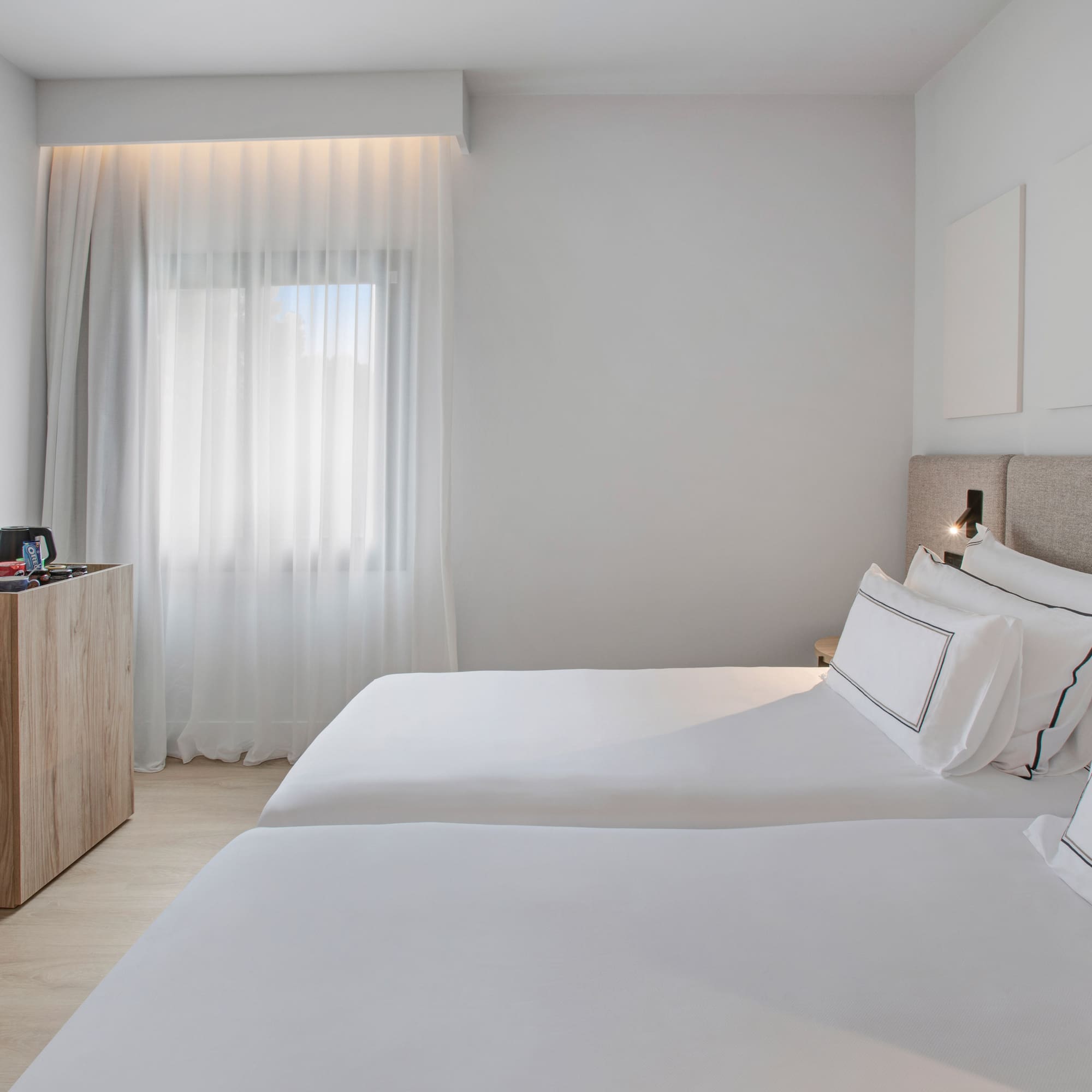 a room with two beds and a dresser