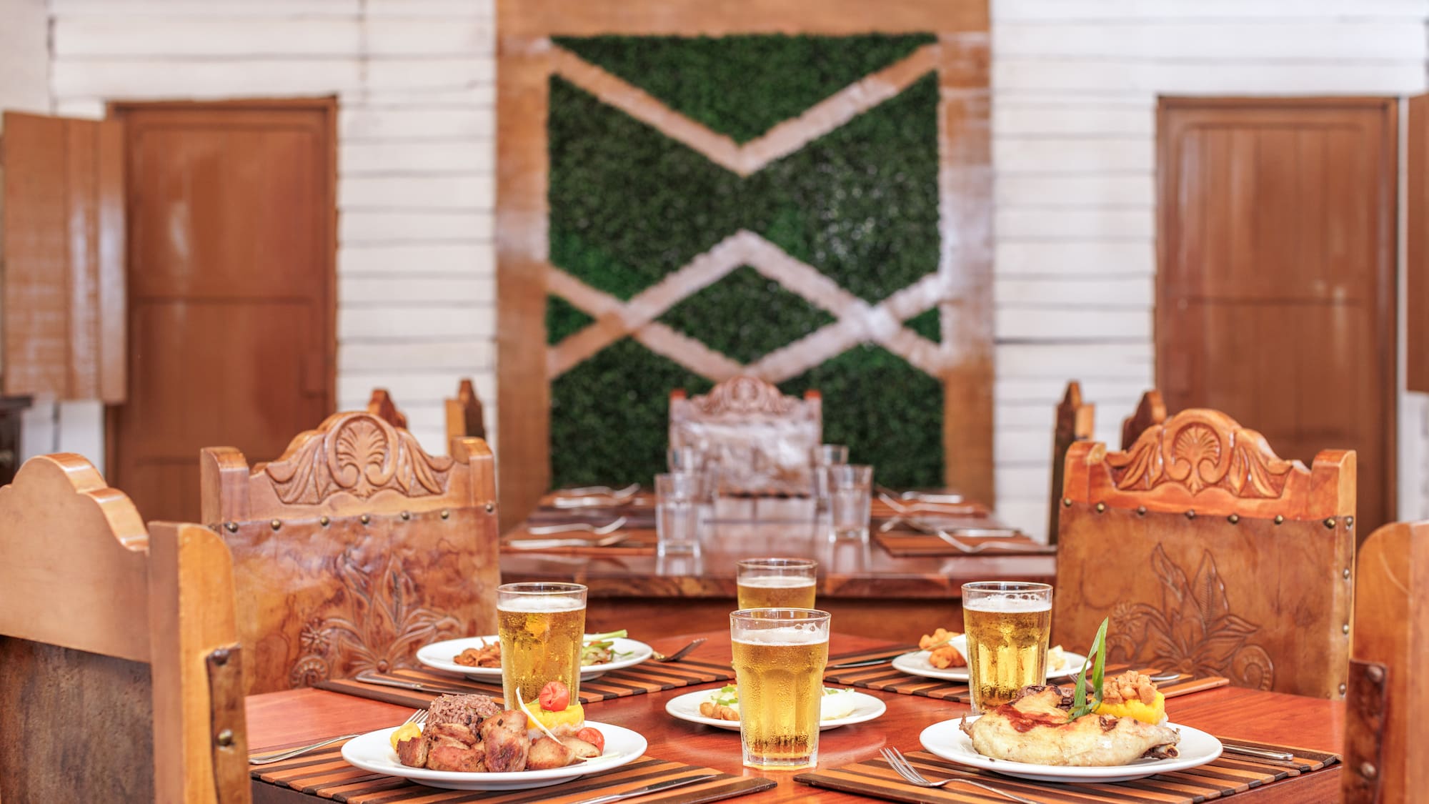 a table with plates of food and glasses of beer