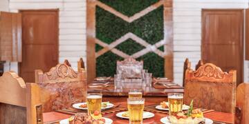 a table with plates of food and glasses of beer