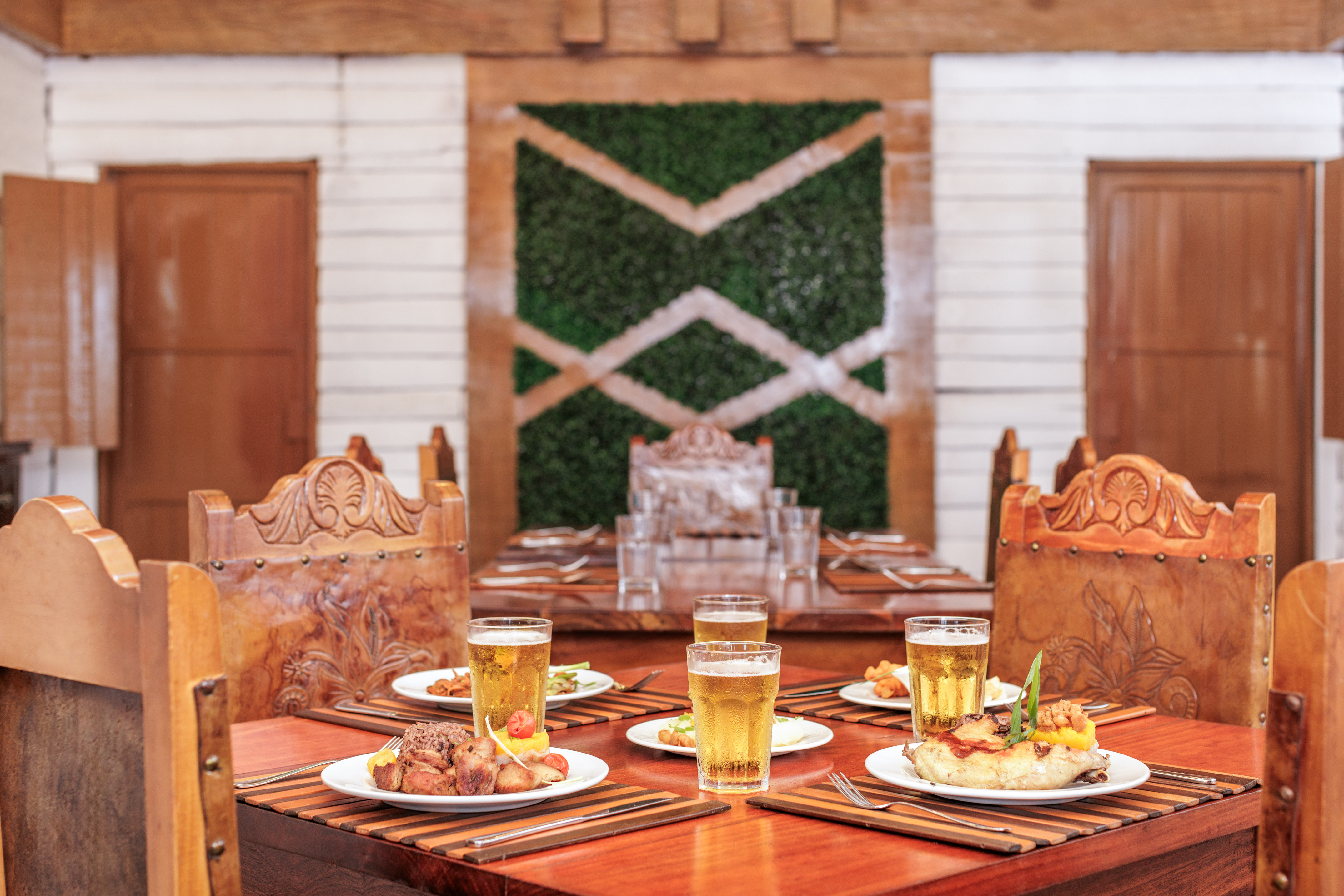 a table with plates of food and glasses of beer