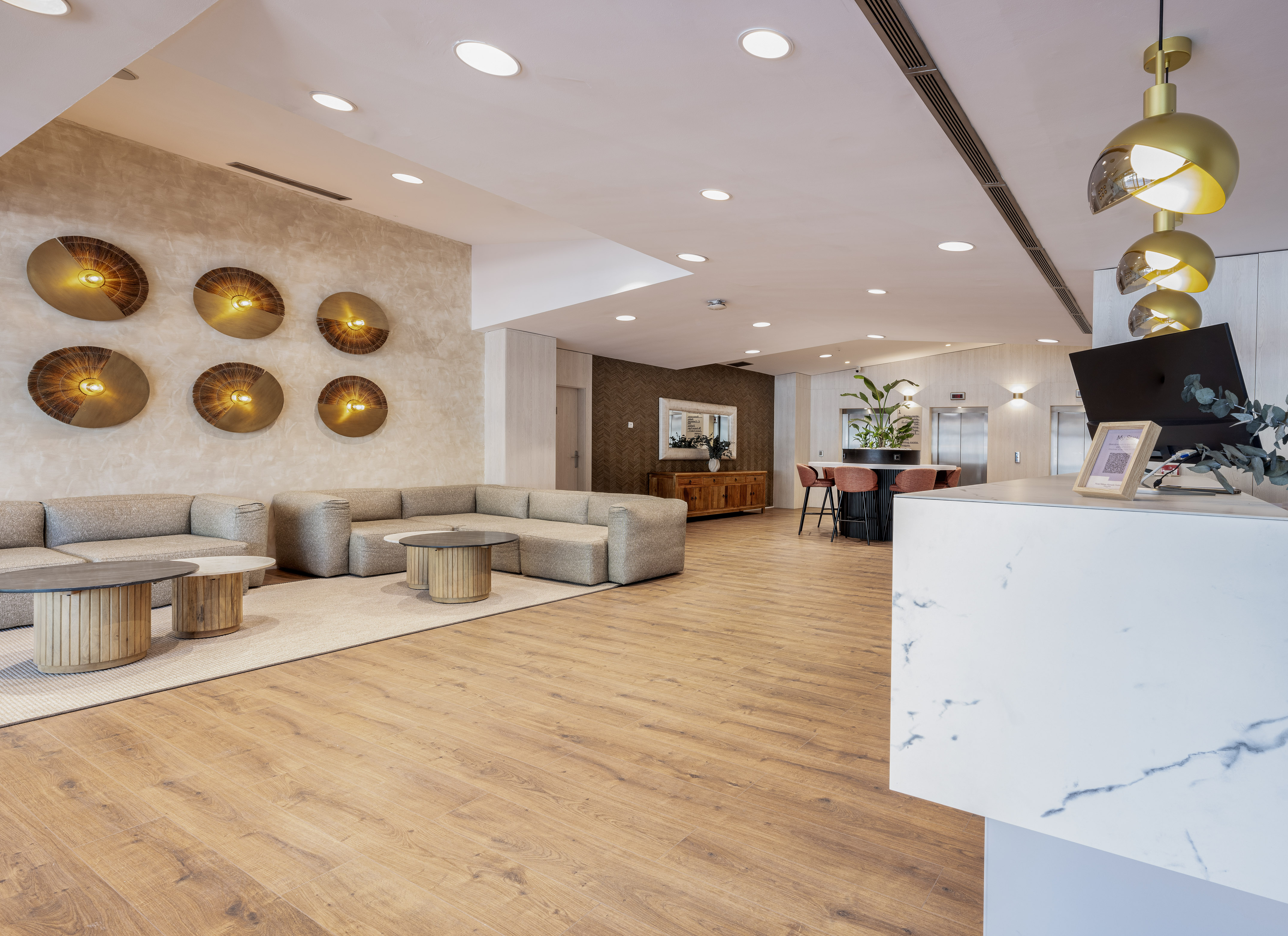 Modern hotel lobby with sleek lounge seating, wood floors, and gold accent lighting.