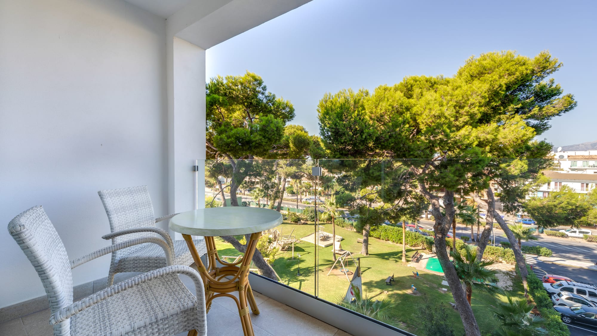 a table and chairs on a balcony overlooking trees and grass
