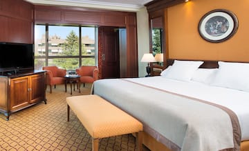 a room with a bed and chairs