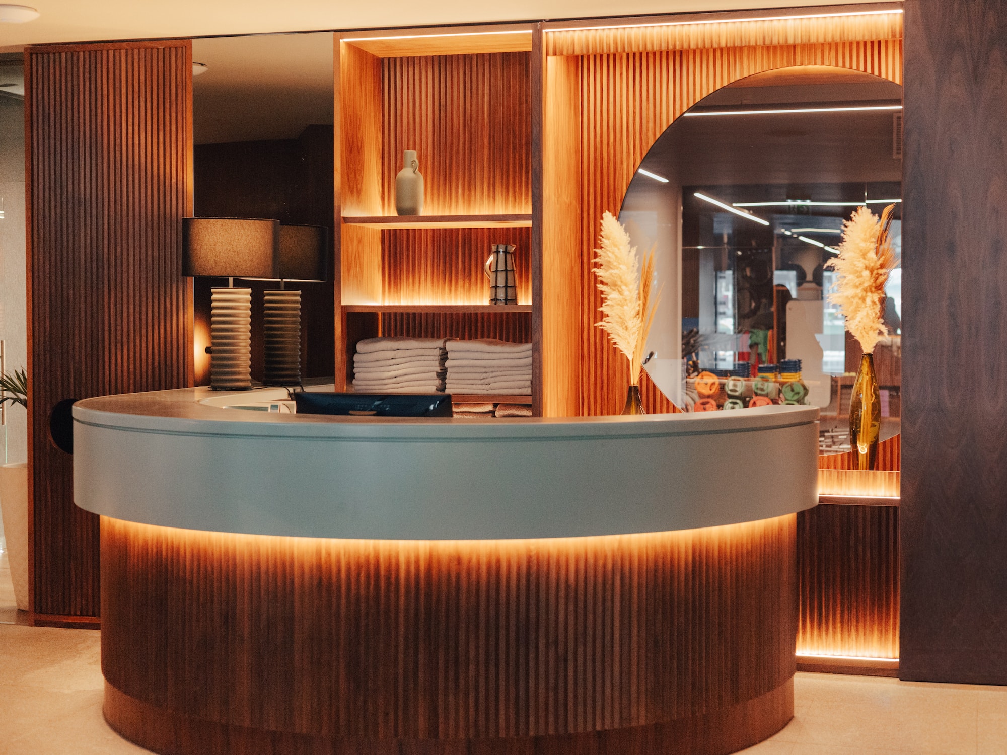 Modern illuminated wooden reception desk in a hotel spa lobby.