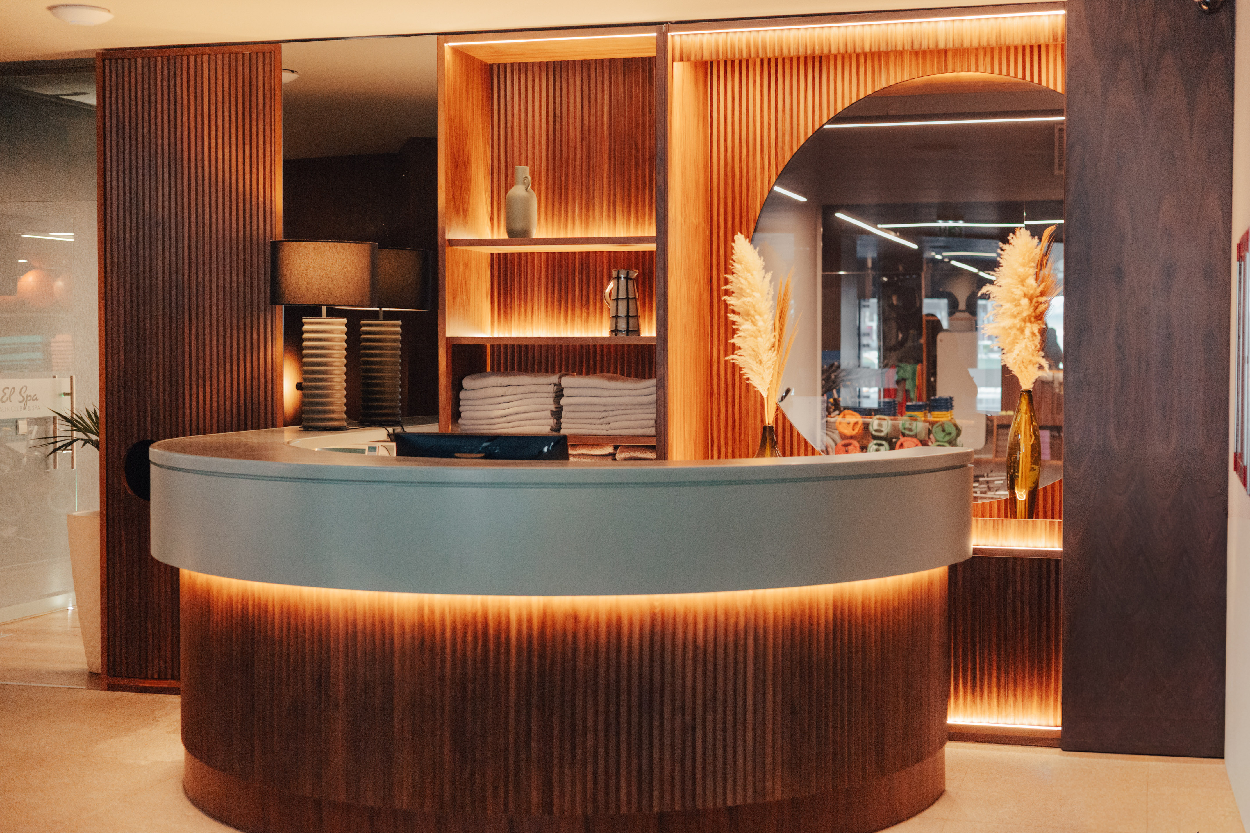 Modern illuminated wooden reception desk in a hotel spa lobby.