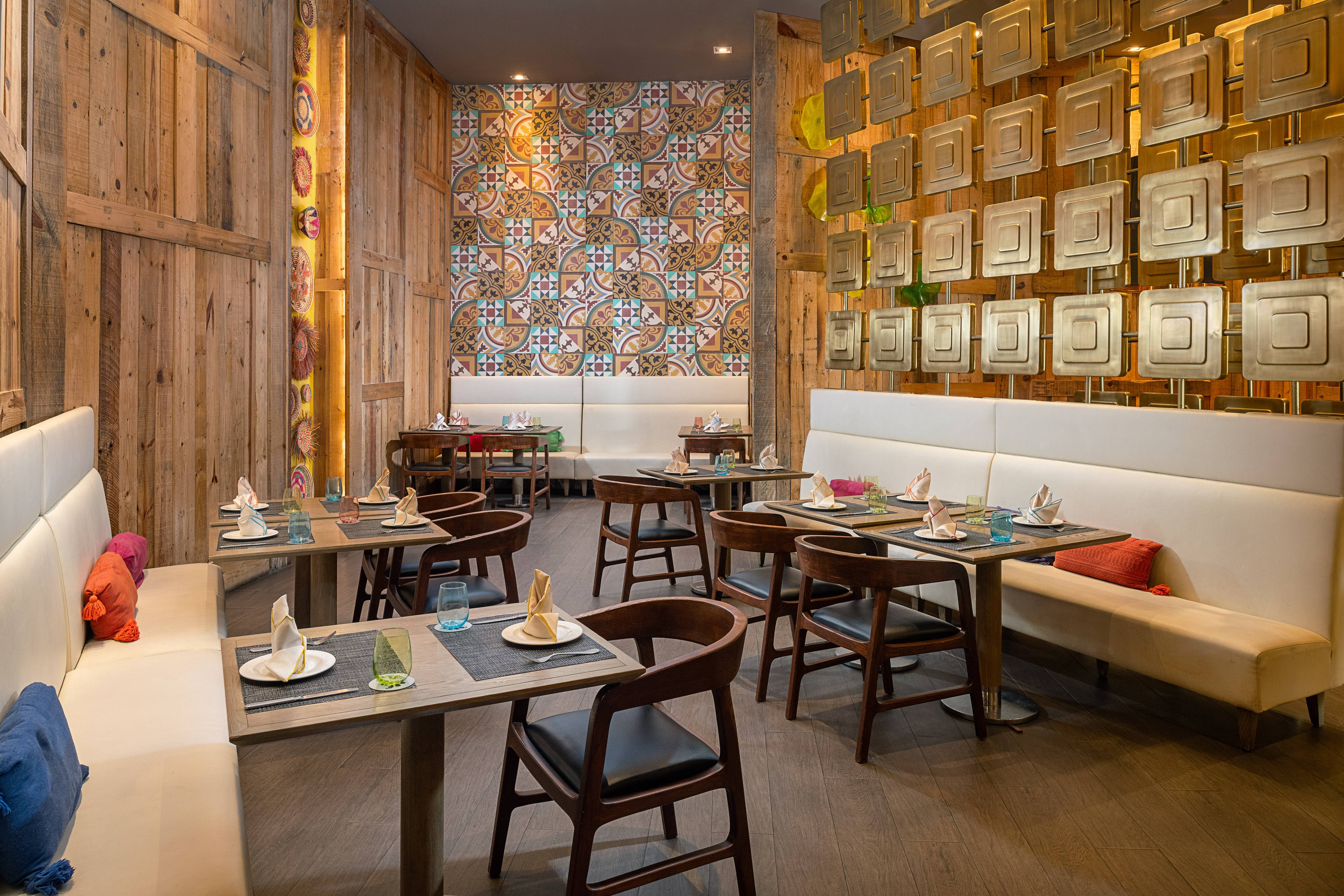Restaurant with wooden walls, comfy booth seating, and patterned tile accents.