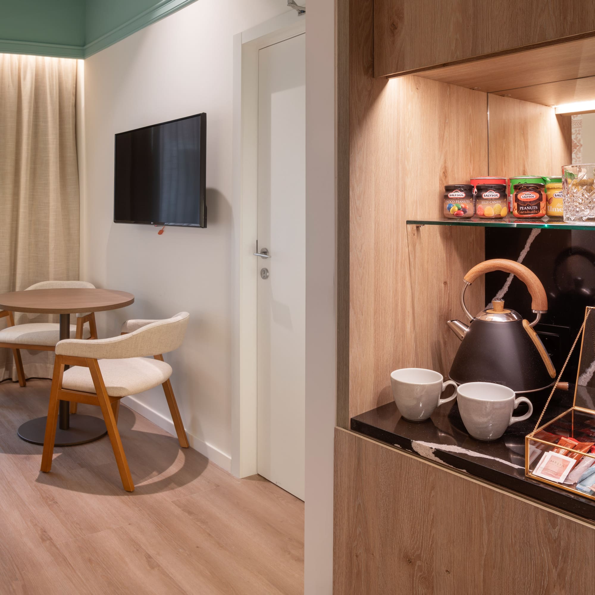 a room with a tv and a table and chairs