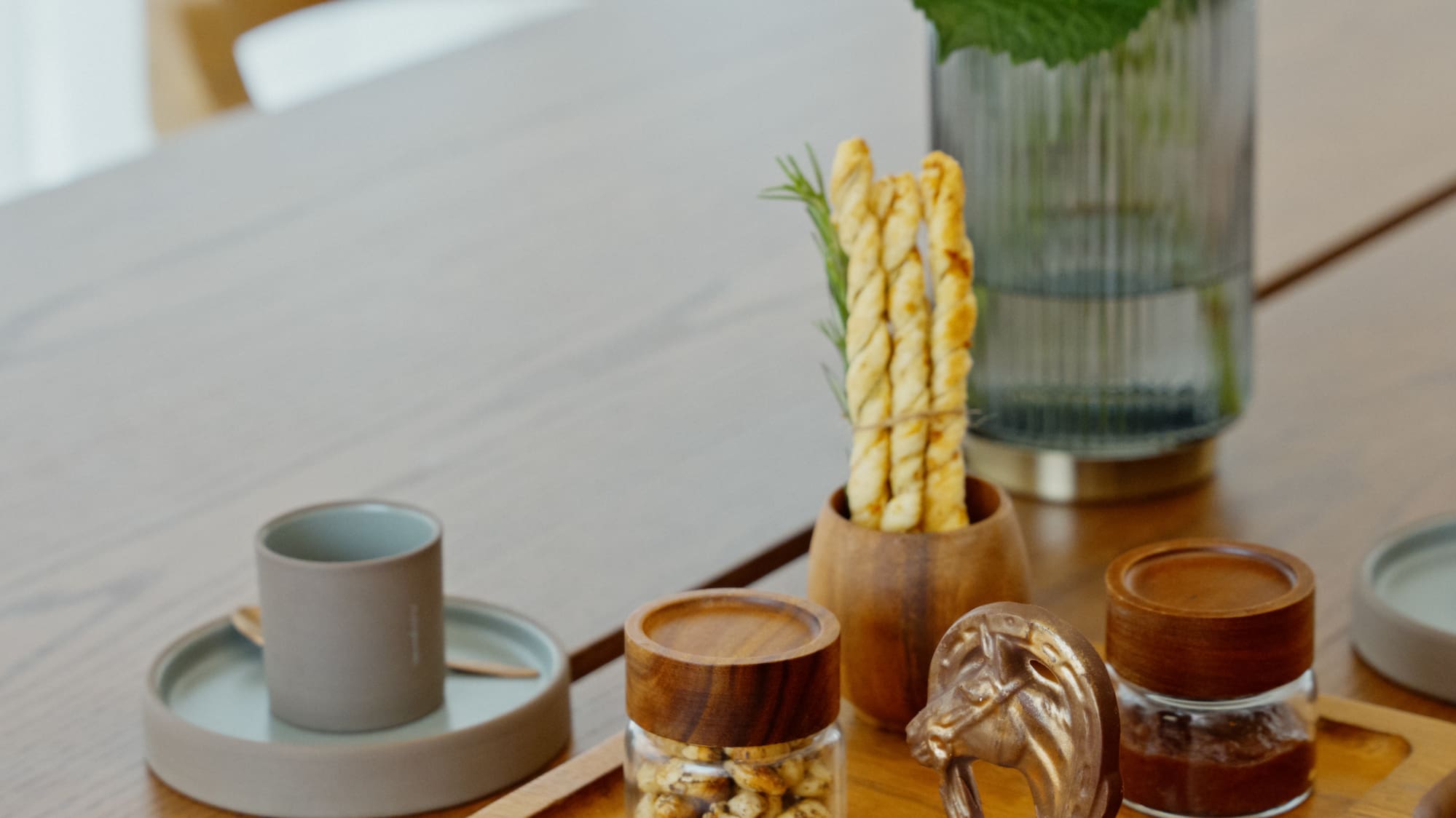 Gourmet chocolates, snacks, breadsticks, and white hydrangeas on wooden table.