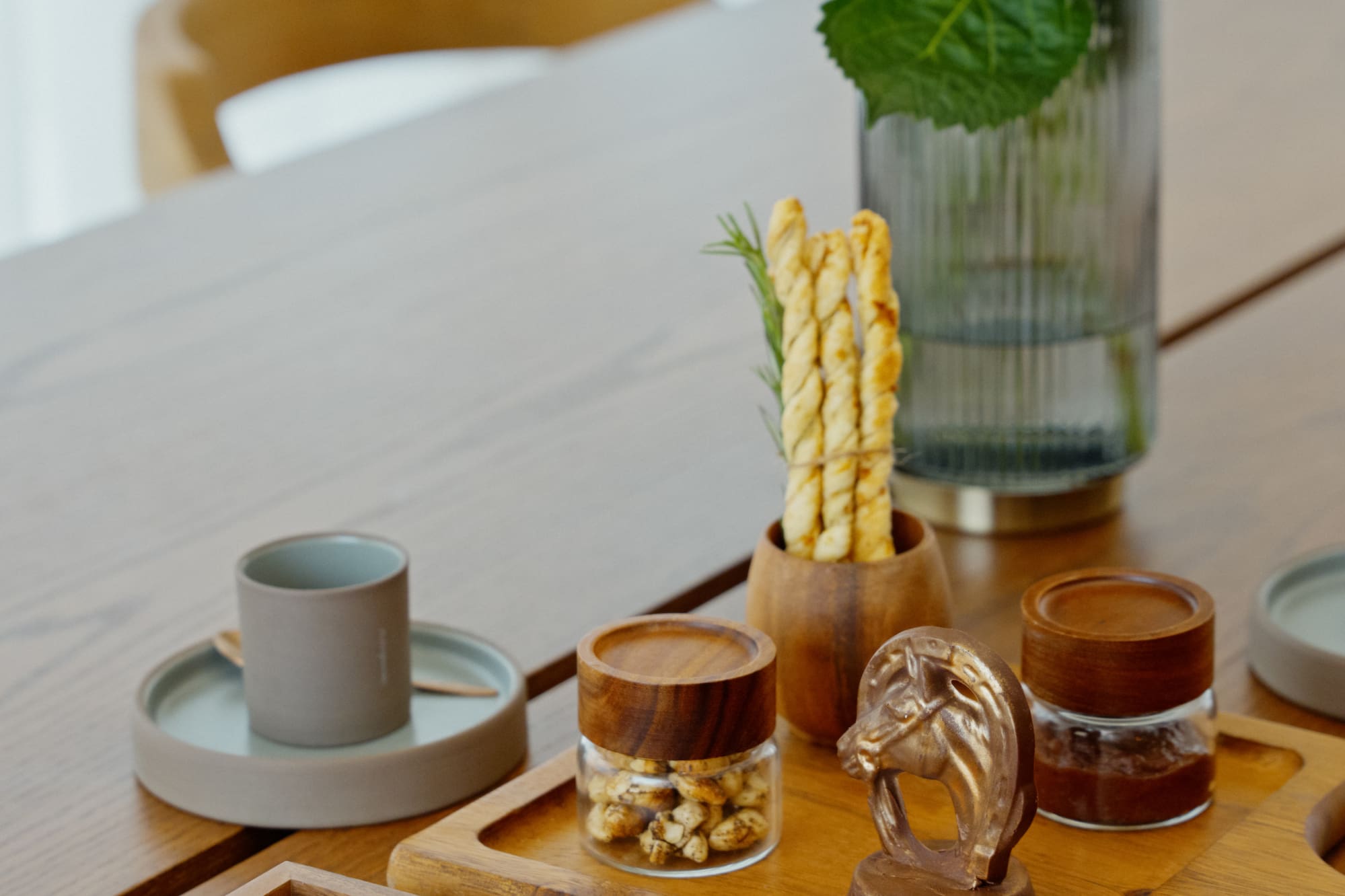 Gourmet chocolates, snacks, breadsticks, and white hydrangeas on wooden table.