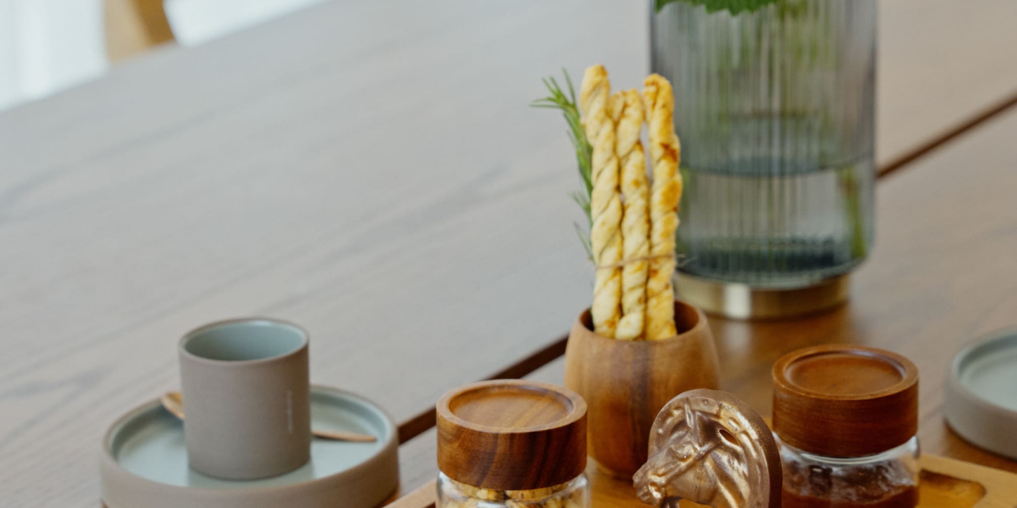 Gourmet chocolates, snacks, breadsticks, and white hydrangeas on wooden table.