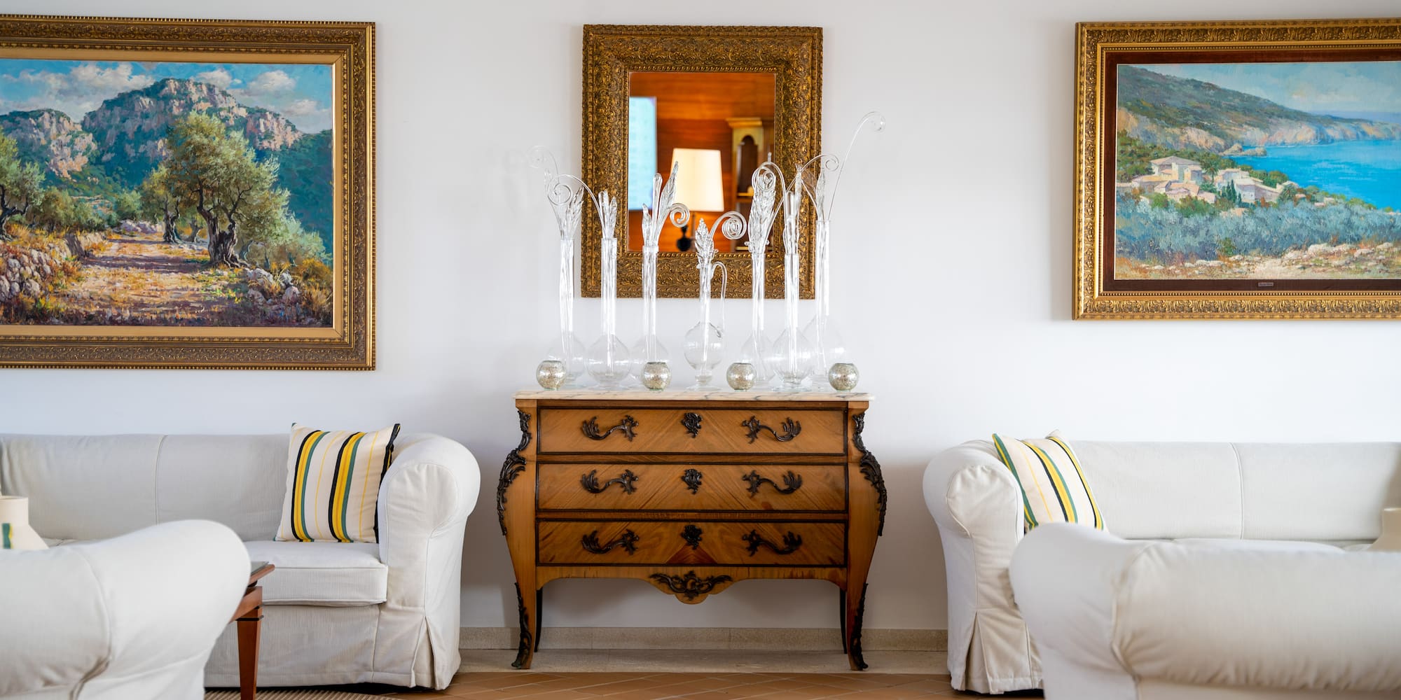 a room with white couches and a dresser