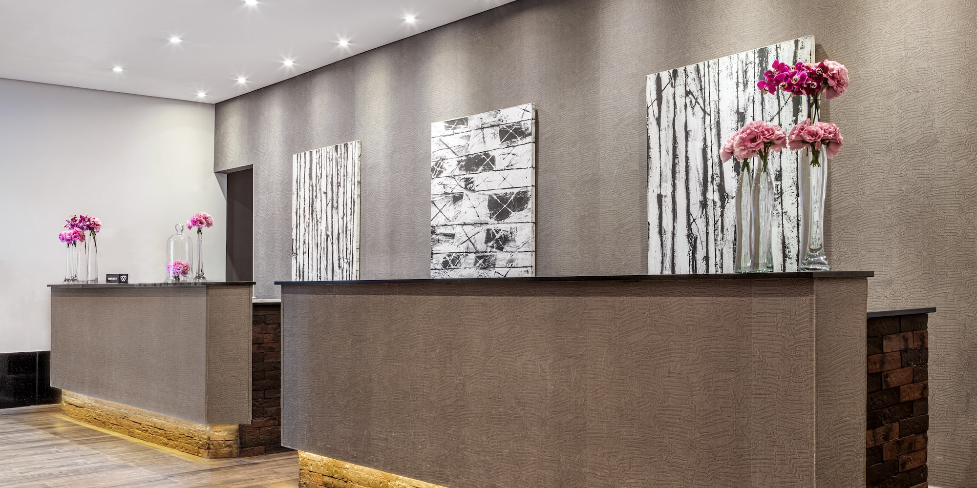 a reception desk with flowers on the wall