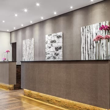 a reception desk with flowers on the wall