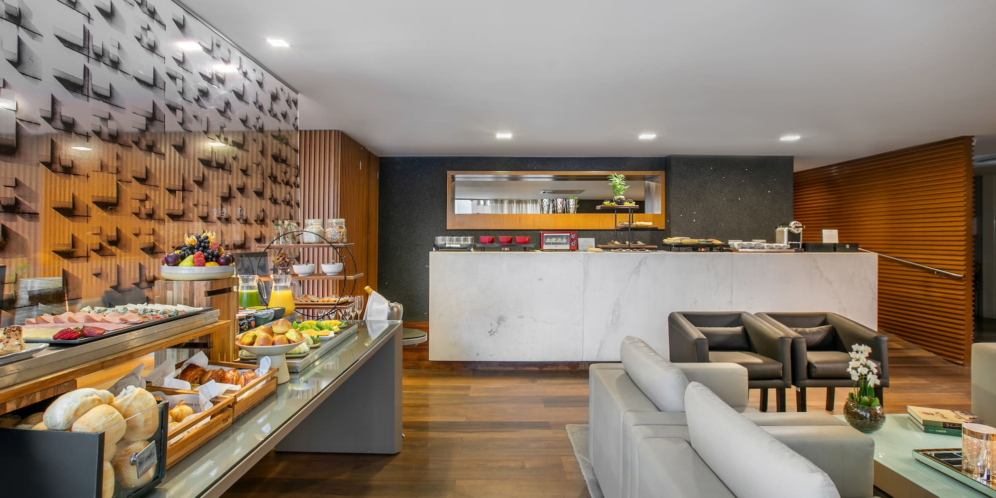 Modern hotel breakfast buffet with fresh food and a stylish lounge area.