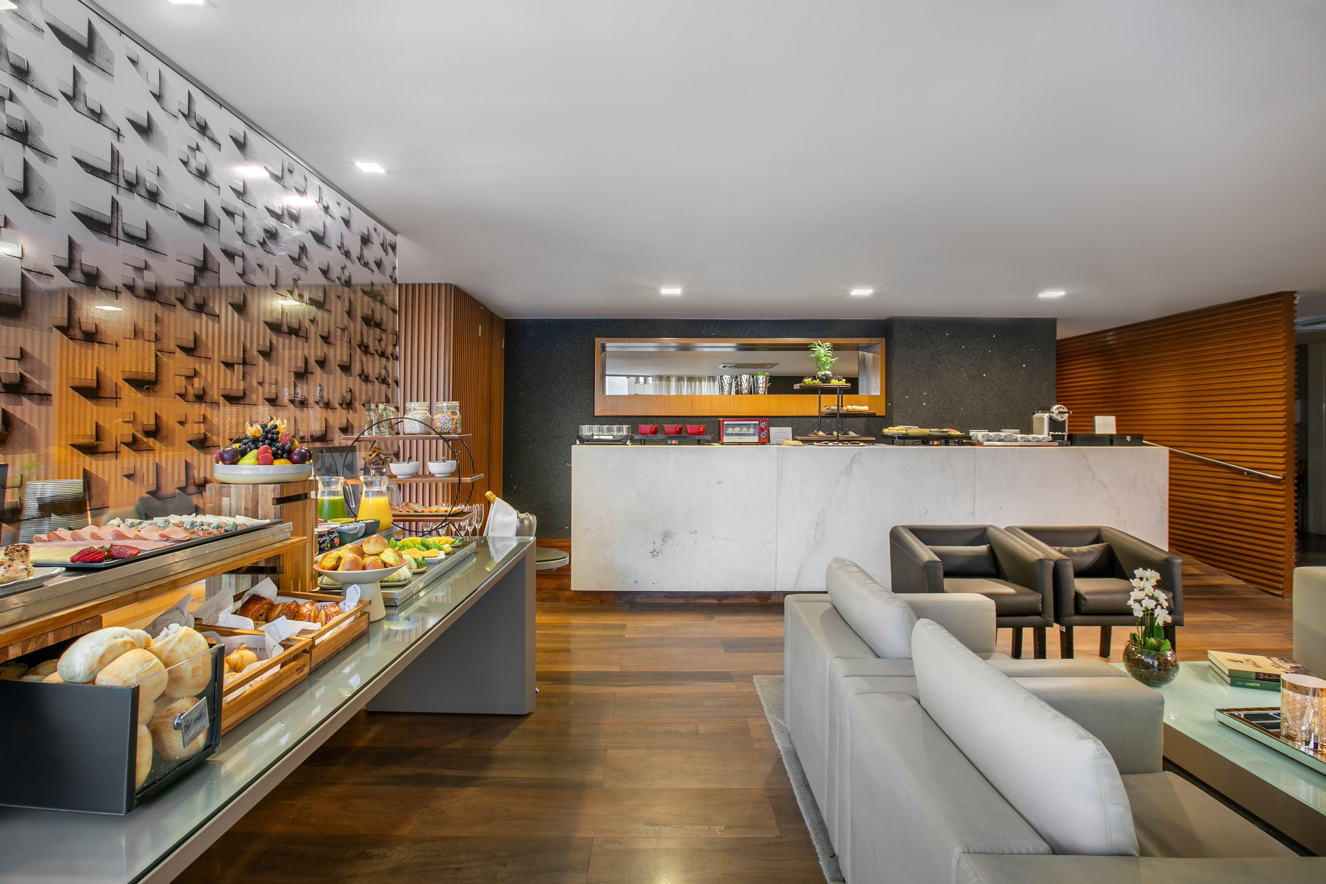 Modern hotel breakfast buffet with fresh food and a stylish lounge area.
