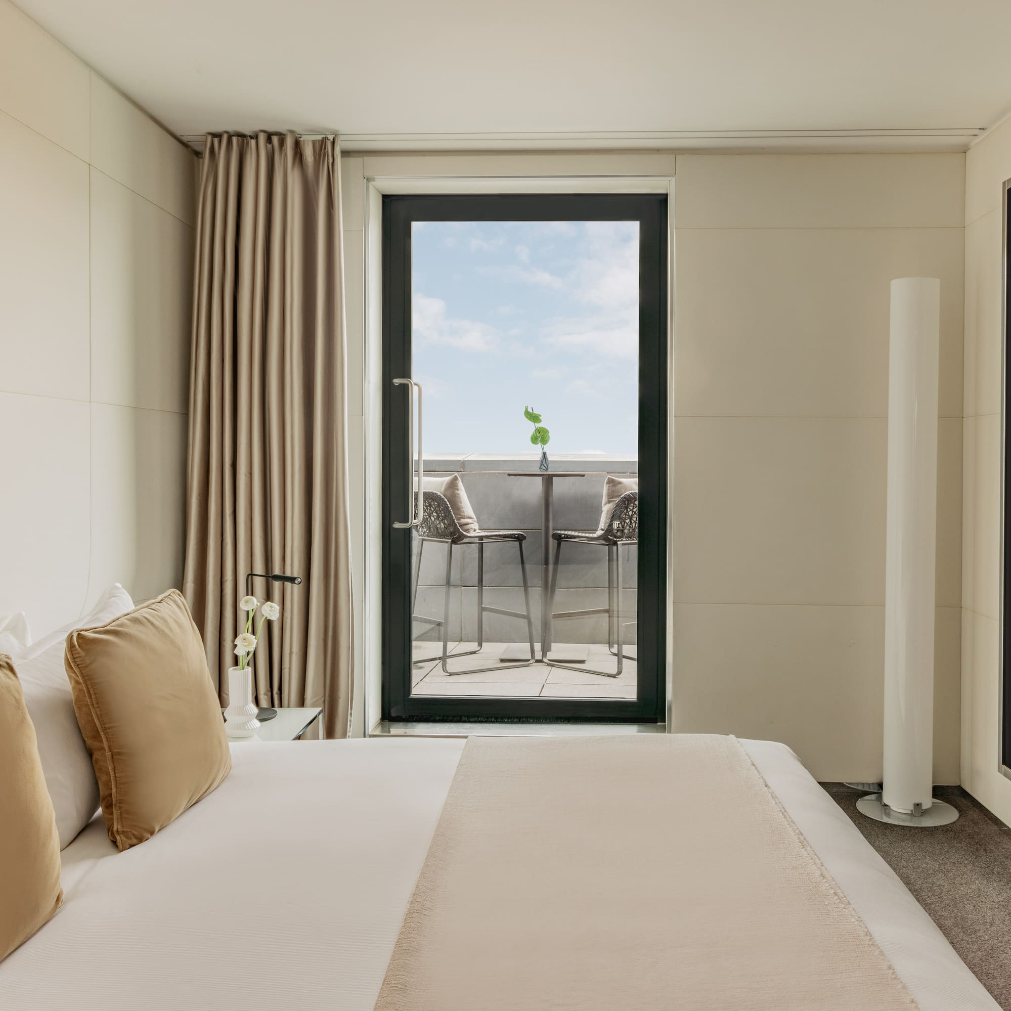 a bed with pillows and a glass door