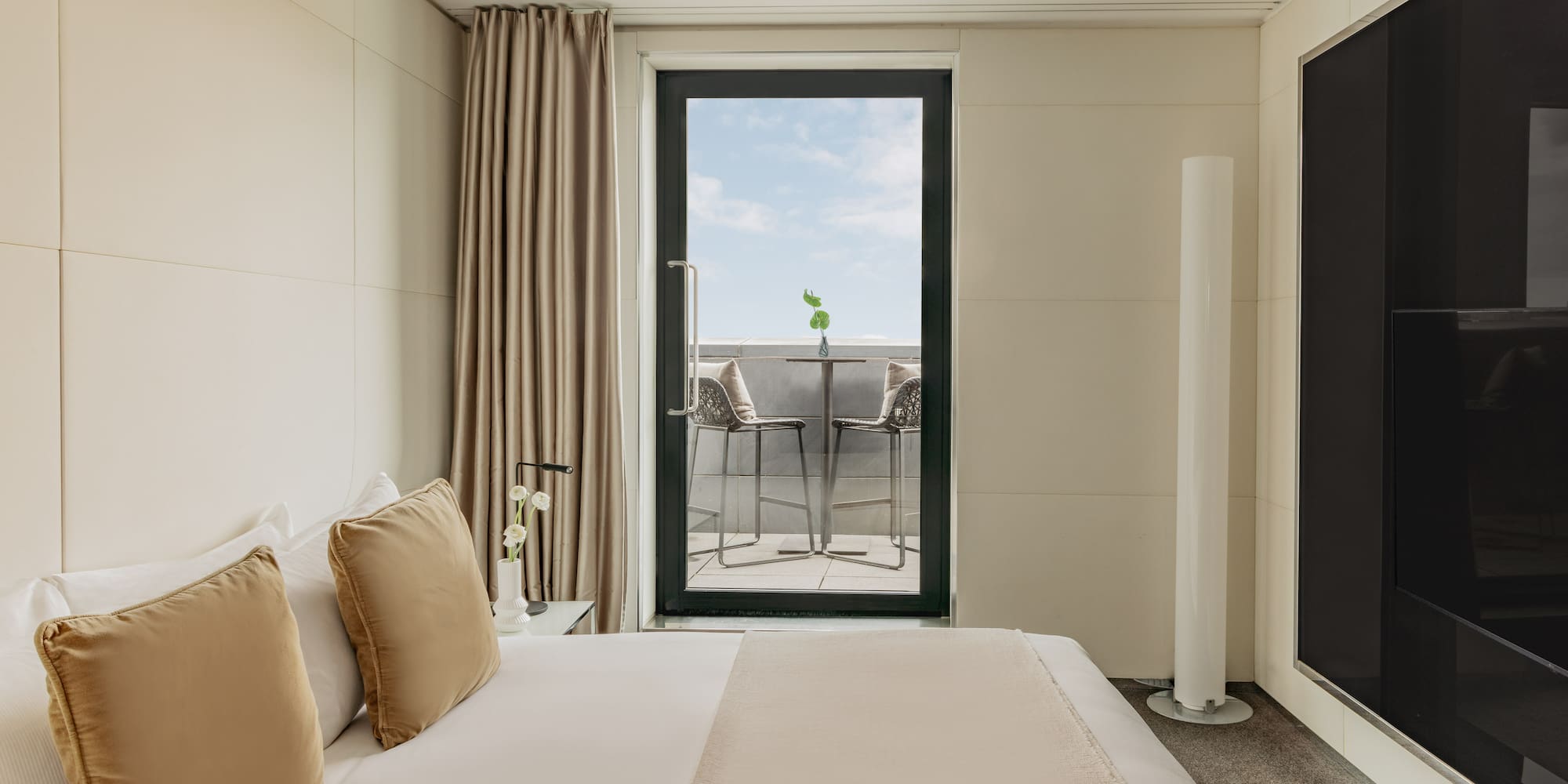 a bed with pillows and a glass door