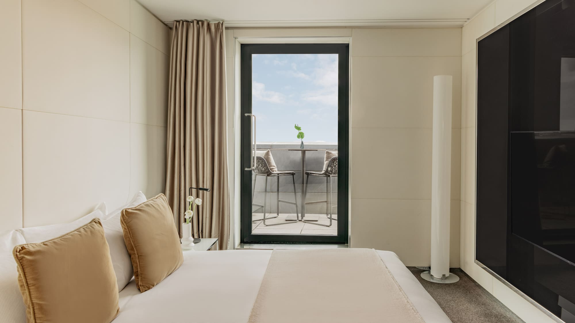 a bed with pillows and a glass door